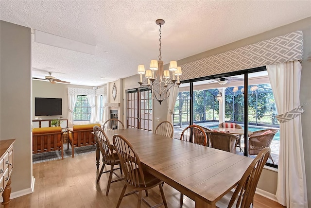 4917 Leatha Ln, Sarasota, FL 34232 - dining area featuring a ceiling fan, a textured ceiling, light wood-type flooring, a chandelier, and a sunroom