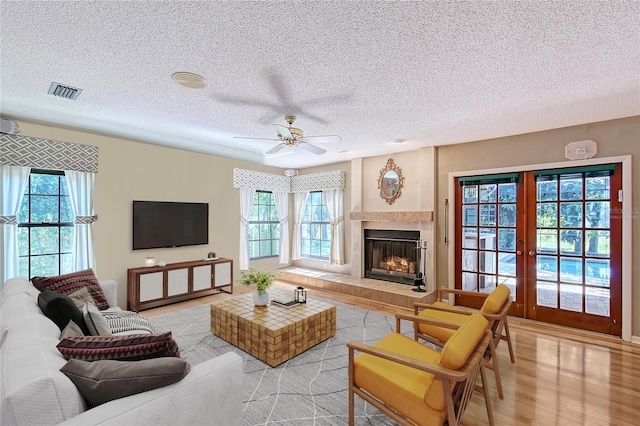 4917 Leatha Ln, Sarasota, FL 34232 - living room featuring plenty of natural light, light wood finished floors, a textured ceiling, french doors, and ceiling fan