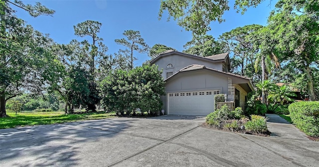 4917 Leatha Ln, Sarasota, FL 34232 - view of home's exterior featuring driveway, stone siding, and a garage