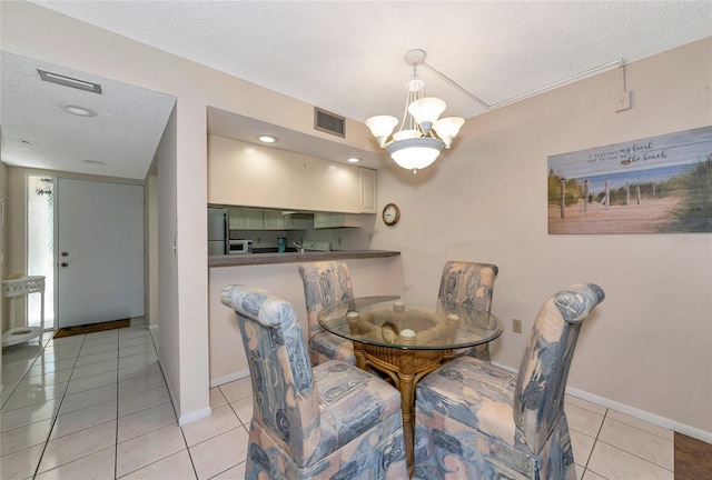 4650 Ringwood Mdw Unit 37, Sarasota, FL 34235 - dining area with a textured ceiling, baseboards, light tile patterned flooring, and a chandelier