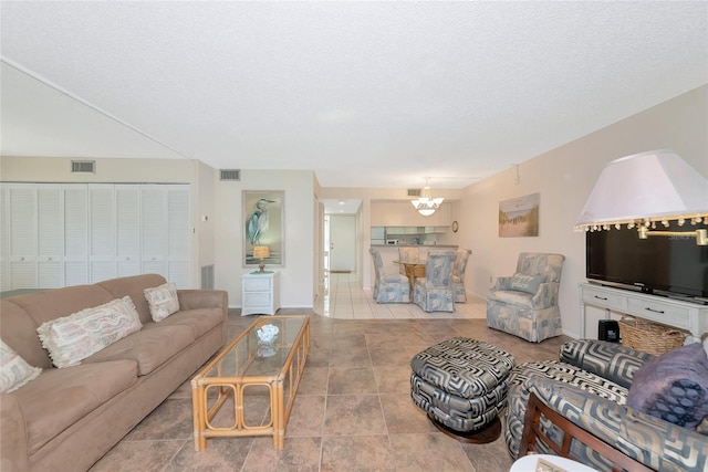 4650 Ringwood Mdw Unit 37, Sarasota, FL 34235 - living area featuring a chandelier, a textured ceiling, baseboards, and tile patterned flooring