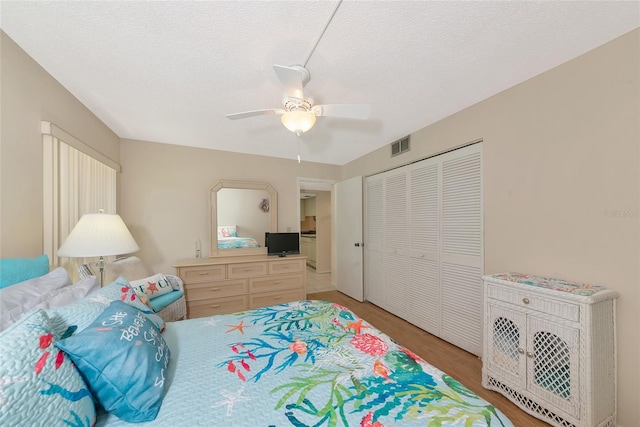 4650 Ringwood Mdw Unit 37, Sarasota, FL 34235 - bedroom featuring light wood-style floors, a closet, ceiling fan, and a textured ceiling