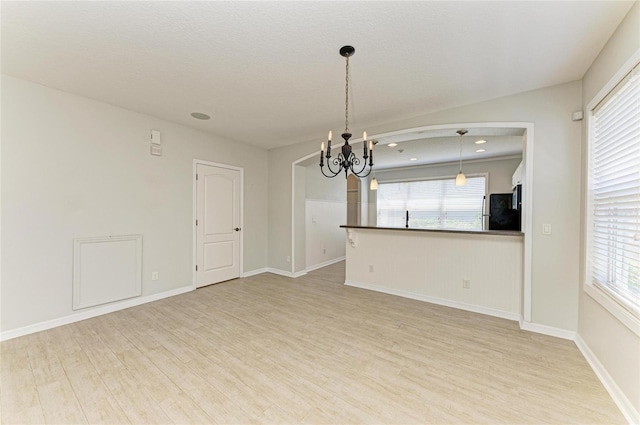 5420 River Sound Ter, Bradenton, FL 34208 - spare room featuring a chandelier, light wood-type flooring, plenty of natural light, and baseboards
