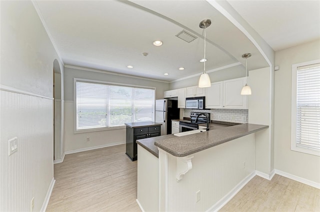 5420 River Sound Ter, Bradenton, FL 34208 - kitchen with stainless steel appliances, dark countertops, light wood-style floors, decorative backsplash, and recessed lighting