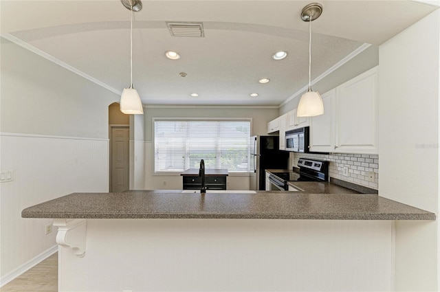 5420 River Sound Ter, Bradenton, FL 34208 - kitchen with stainless steel range with electric cooktop, dark countertops, freestanding refrigerator, a peninsula, and decorative backsplash