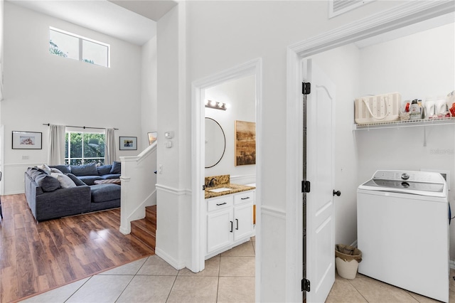 6032 36th Ct E, Ellenton, FL 34222 - laundry room with washer / dryer, light tile patterned floors, a towering ceiling, and baseboards