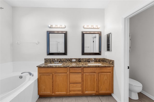 6032 36th Ct E, Ellenton, FL 34222 - bathroom with double vanity, a garden tub, toilet, tile patterned flooring, and baseboards