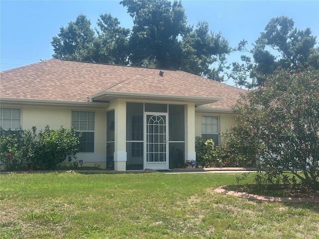 4027 Allure Ln, North Port, FL 34287 - rear view of house featuring a shingled roof, stucco siding, and a yard