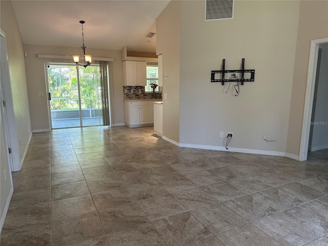 4027 Allure Ln, North Port, FL 34287 - unfurnished living room with stone finish floors and a chandelier