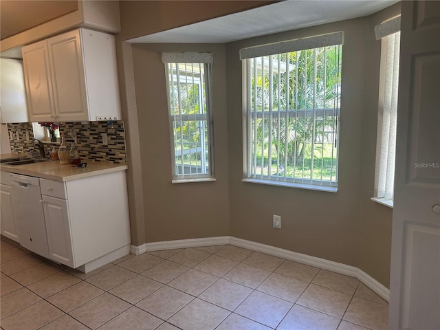 4027 Allure Ln, North Port, FL 34287 - kitchen featuring white dishwasher, tasteful backsplash, light tile patterned floors, white cabinetry, and light countertops