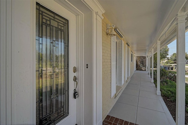 149 Small St SE, Port Charlotte, FL 33952 - doorway to property featuring a porch and brick siding