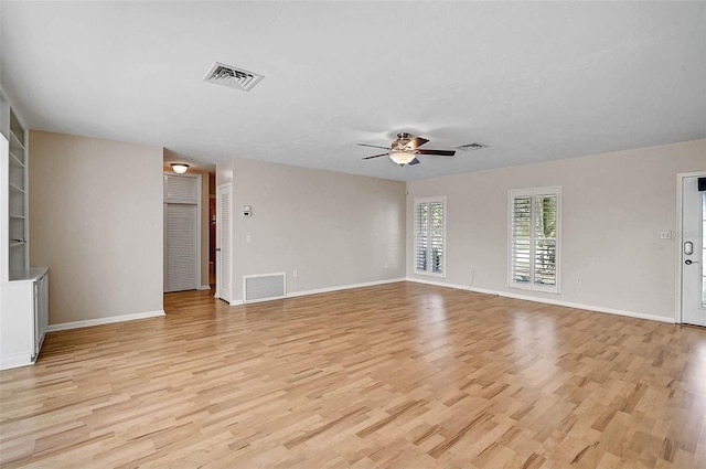 149 Small St SE, Port Charlotte, FL 33952 - unfurnished living room with light wood-type flooring, a ceiling fan, and baseboards