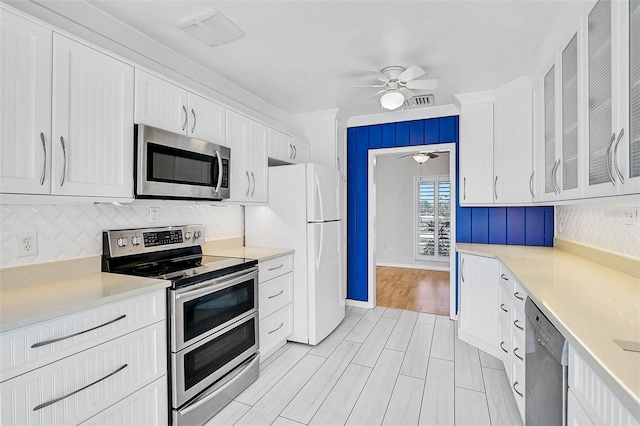 149 Small St SE, Port Charlotte, FL 33952 - kitchen featuring stainless steel appliances, ceiling fan, white cabinetry, decorative backsplash, and light countertops