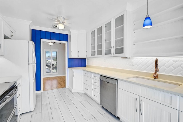 149 Small St SE, Port Charlotte, FL 33952 - kitchen with stainless steel appliances, ceiling fan, a sink, white cabinetry, and glass insert cabinets
