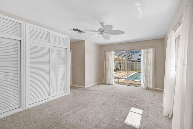 149 Small St SE, Port Charlotte, FL 33952 - unfurnished bedroom with access to exterior, carpet, baseboards, a closet, and ceiling fan