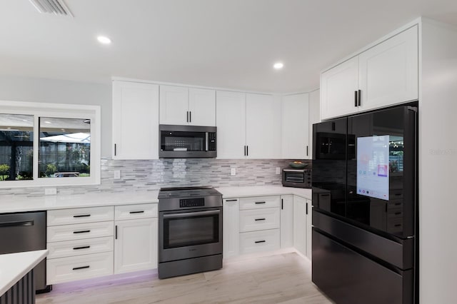 5581 Shadow Lawn Dr, Sarasota, FL 34242 - kitchen with smart refrigerator, stainless steel electric range oven, dishwashing machine, light countertops, and decorative backsplash