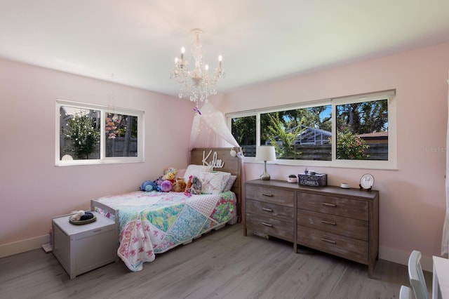 5581 Shadow Lawn Dr, Sarasota, FL 34242 - bedroom featuring a chandelier, light wood-type flooring, and baseboards