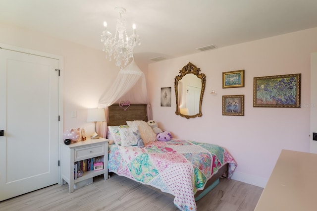 5581 Shadow Lawn Dr, Sarasota, FL 34242 - bedroom with a chandelier, wood finished floors, and baseboards