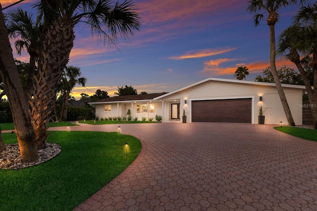 5581 Shadow Lawn Dr, Sarasota, FL 34242 - ranch-style home with decorative driveway, an attached garage, stucco siding, and a lawn