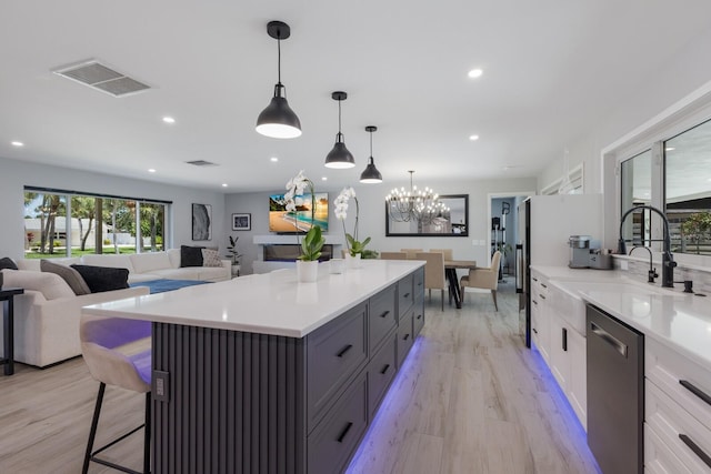 5581 Shadow Lawn Dr, Sarasota, FL 34242 - kitchen featuring stainless steel dishwasher, a sink, light wood-style floors, light countertops, and recessed lighting