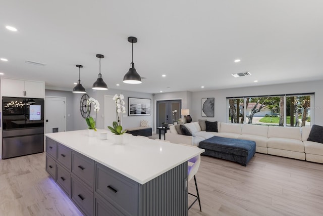 5581 Shadow Lawn Dr, Sarasota, FL 34242 - kitchen featuring recessed lighting, a kitchen island, a kitchen bar, light countertops, and open floor plan