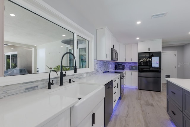 5581 Shadow Lawn Dr, Sarasota, FL 34242 - kitchen featuring stainless steel appliances, a sink, tasteful backsplash, light countertops, and white cabinets