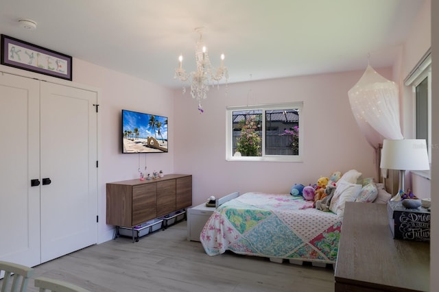 5581 Shadow Lawn Dr, Sarasota, FL 34242 - bedroom featuring a chandelier, light wood-style floors, and a closet