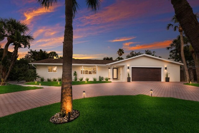 5581 Shadow Lawn Dr, Sarasota, FL 34242 - single story home with decorative driveway, stucco siding, a garage, and a yard