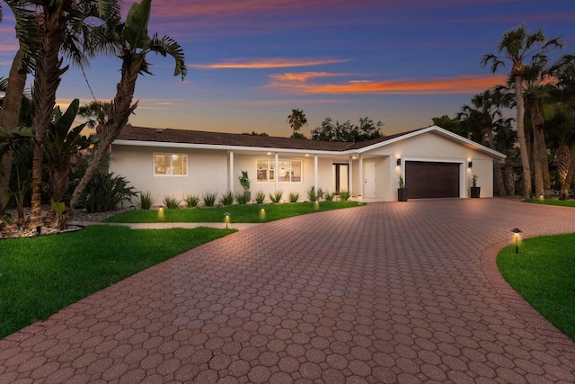 5581 Shadow Lawn Dr, Sarasota, FL 34242 - ranch-style house featuring decorative driveway, a garage, a front lawn, and stucco siding
