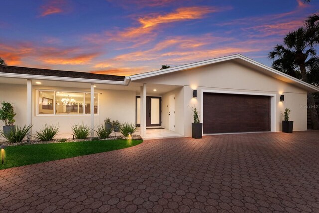 5581 Shadow Lawn Dr, Sarasota, FL 34242 - view of front of home featuring an attached garage, stucco siding, and decorative driveway