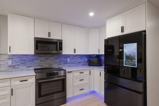 5581 Shadow Lawn Dr, Sarasota, FL 34242 - kitchen featuring appliances with stainless steel finishes, light countertops, white cabinets, and recessed lighting