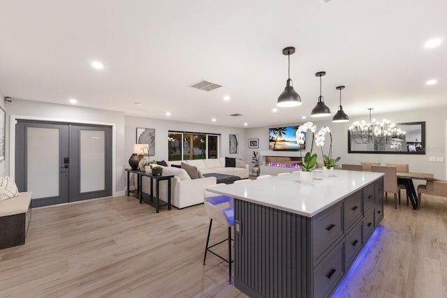5581 Shadow Lawn Dr, Sarasota, FL 34242 - kitchen with a kitchen island, light wood-style floors, recessed lighting, light countertops, and french doors