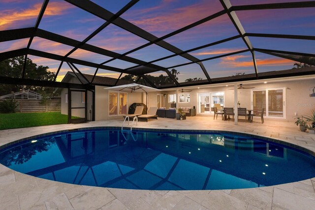 5581 Shadow Lawn Dr, Sarasota, FL 34242 - pool at dusk featuring an outdoor pool, a ceiling fan, an outdoor living space, and a patio area