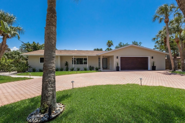 5581 Shadow Lawn Dr, Sarasota, FL 34242 - ranch-style home featuring decorative driveway, stucco siding, a front lawn, and a garage