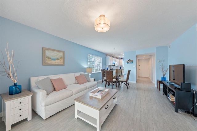 110 Vista Hermosa Cir Unit 302B, Sarasota, FL 34242 - living room featuring light wood-type flooring, a chandelier, and baseboards