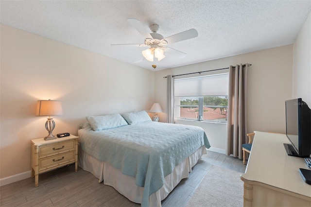 110 Vista Hermosa Cir Unit 302B, Sarasota, FL 34242 - bedroom with light wood-style flooring, baseboards, a textured ceiling, and a ceiling fan