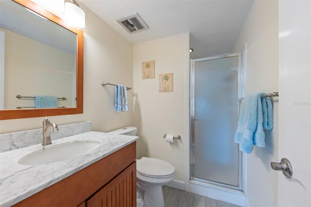 110 Vista Hermosa Cir Unit 302B, Sarasota, FL 34242 - bathroom featuring vanity, toilet, a shower stall, wood finished floors, and a textured ceiling