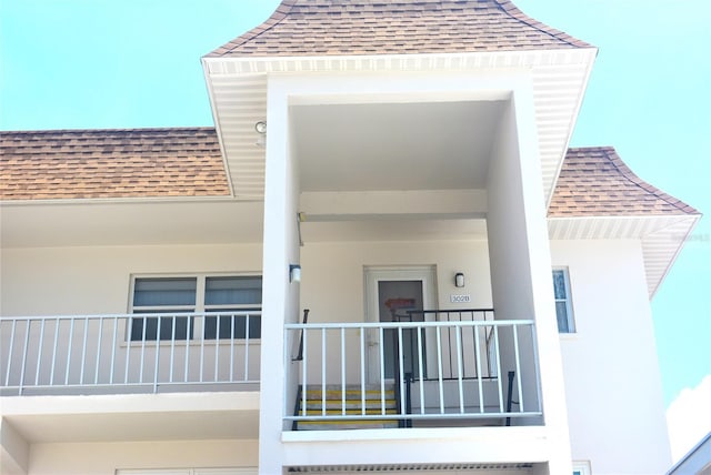 110 Vista Hermosa Cir Unit 302B, Sarasota, FL 34242 - doorway to property with roof with shingles and stucco siding