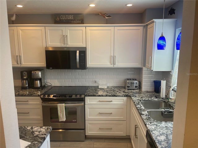 110 Vista Hermosa Cir Unit 302B, Sarasota, FL 34242 - kitchen featuring appliances with stainless steel finishes, a sink, decorative backsplash, dark stone counters, and recessed lighting
