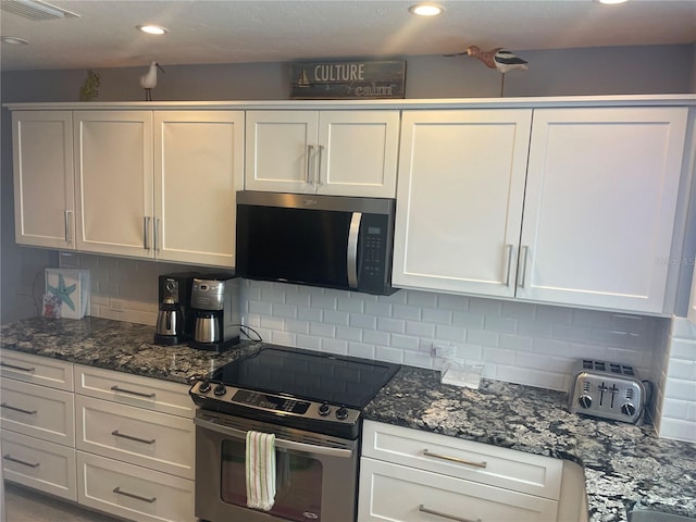 110 Vista Hermosa Cir Unit 302B, Sarasota, FL 34242 - kitchen featuring stainless steel appliances, decorative backsplash, white cabinets, dark stone countertops, and recessed lighting