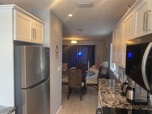 110 Vista Hermosa Cir Unit 302B, Sarasota, FL 34242 - kitchen with appliances with stainless steel finishes, dark stone countertops, light wood finished floors, white cabinets, and recessed lighting