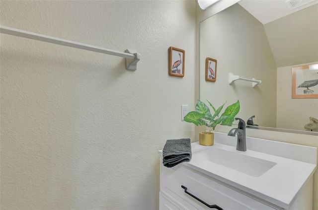 1216 Rio De Janeiro Ave Unit 306, Punta Gorda, FL 33983 - bathroom featuring vanity, lofted ceiling, and a textured wall