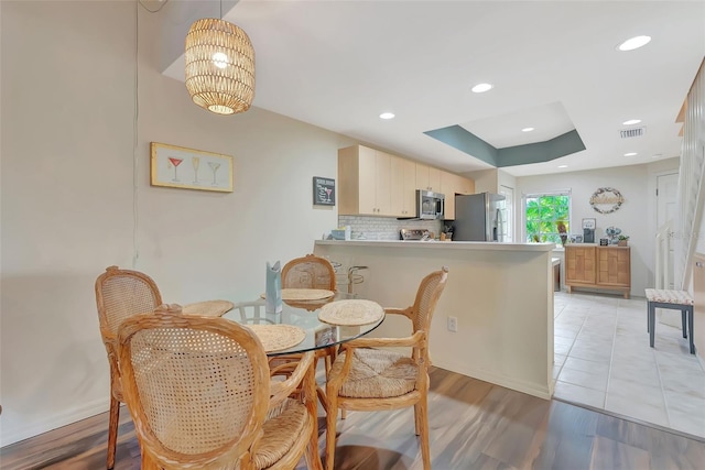 1216 Rio De Janeiro Ave Unit 306, Punta Gorda, FL 33983 - dining room featuring baseboards, light wood-style floors, recessed lighting, and a tray ceiling