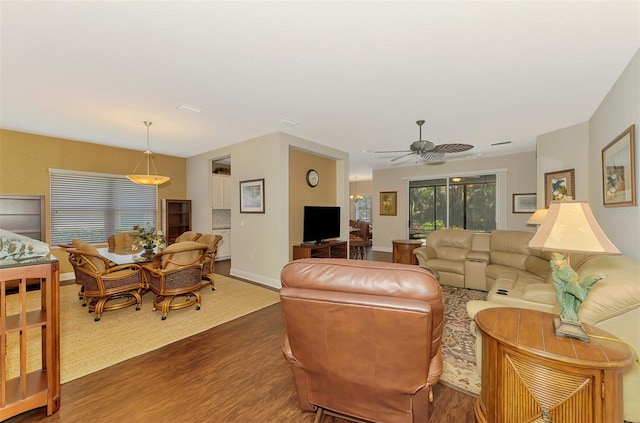 12229 Stuart Dr, Venice, FL 34293 - living area featuring wood finished floors, a ceiling fan, and baseboards