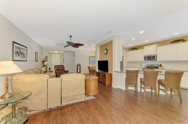 12229 Stuart Dr, Venice, FL 34293 - living room with dark wood-type flooring, ceiling fan, recessed lighting, and baseboards