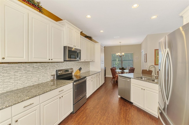 12229 Stuart Dr, Venice, FL 34293 - kitchen with appliances with stainless steel finishes, a sink, dark wood-type flooring, decorative backsplash, and white cabinets