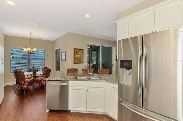 12229 Stuart Dr, Venice, FL 34293 - kitchen featuring stainless steel appliances, a sink, a peninsula, dark wood finished floors, and a chandelier