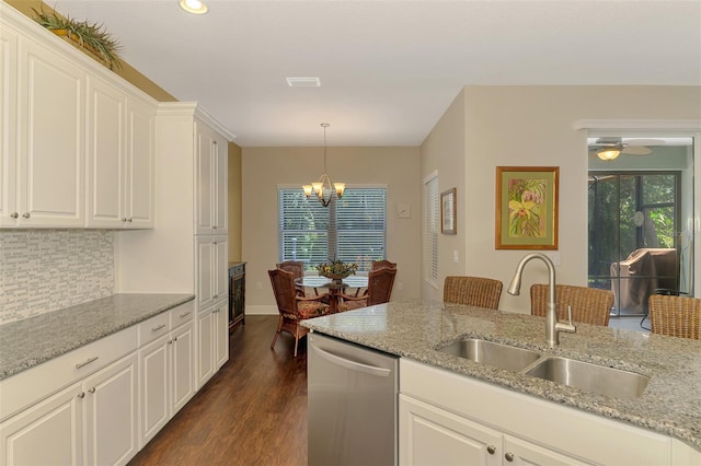 12229 Stuart Dr, Venice, FL 34293 - kitchen with stainless steel dishwasher, a sink, a chandelier, dark wood-type flooring, and tasteful backsplash