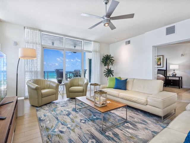 6512 Midnight Pass Rd Unit 301, Sarasota, FL 34242 - living room with expansive windows, a ceiling fan, and light wood-style flooring