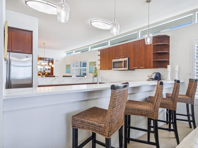 6512 Midnight Pass Rd Unit 301, Sarasota, FL 34242 - kitchen featuring appliances with stainless steel finishes, open shelves, decorative light fixtures, and a peninsula